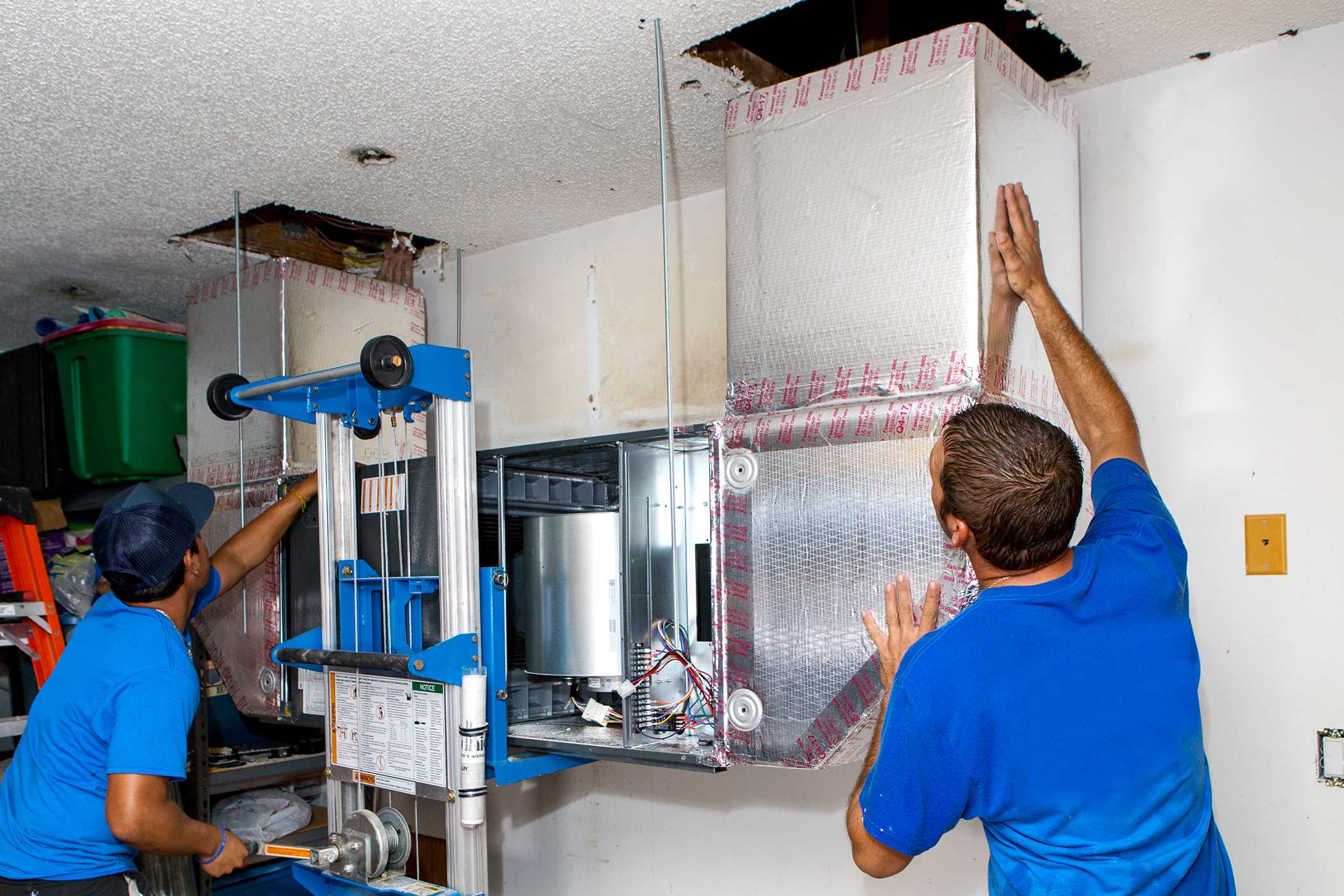 Technicians installing a heat recovery ventilation (HRV) system in a residential setting, showcasing balanced ventilation services for improved indoor air quality in colder climates.