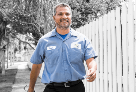 HVAC technician walking on sidewalk in Phenix City, AL, representing Priority Indoor Comfort's furnace tune-up services.