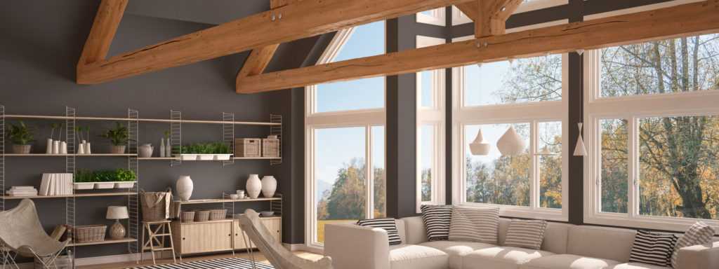 Modern living room with large windows, exposed wooden beams, and stylish furnishings, emphasizing energy efficiency and comfort in home design.