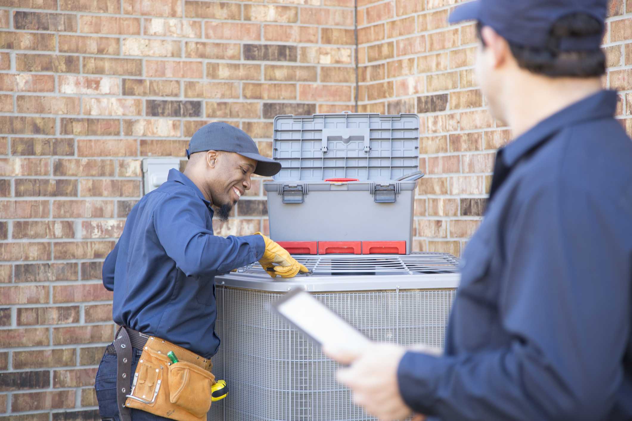 Technicians performing AC maintenance service on a residential air conditioning unit in Phenix City, AL.